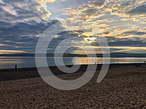 Dramatic sunset with clouds and silhouettes on English beach