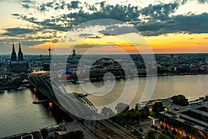 Dramatic sunset cloudscape over Cologne cityscape with a view of Hohenzollern Arch Bridge, Germany