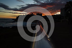 Dramatic sunset with colorful clouds and silhouette of waterfront railing