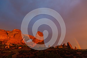 Dramatic sunset colors, clouds and rain in Arches National Park desert