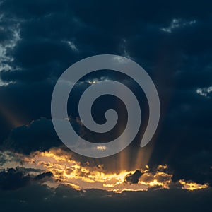 Dramatic sunset with dark clouds and glimpses of light.