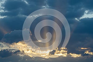 Dramatic sunset with dark clouds and glimpses of light.