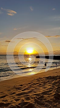 Dramatic Sunset dropping behind the ocean on Kaimana Beach