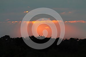 Dramatic sunset with golden sun rays piercing through clouds.