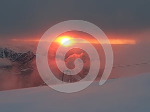 Dramatic sunset in the mountain. Cloudy sky at sunset. High mountain snowy landscape