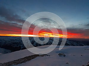 Dramatic sunset in the mountain. Cloudy sky at sunset. High mountain snowy landscape