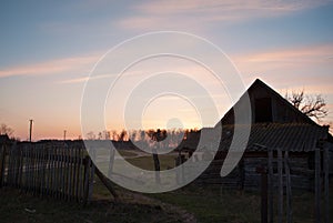 Dramatic sunset with old wooden barn in the countryside