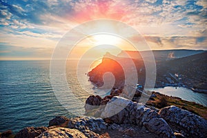 Dramatic sunset over Crimean rock cliff, beautiful sea nature landscape, summer travel and freedom