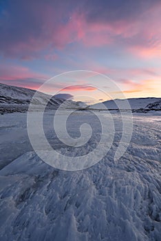 Dramatic sunset over the icy lake in the Arctic tundra. Yamal peninsula.