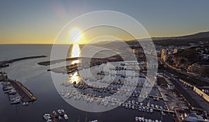 Dramatic sunset over the mediterranean sea in El Maresme Coast. Aerial panoramic view of Arenys de Mar harbor at dawn photo