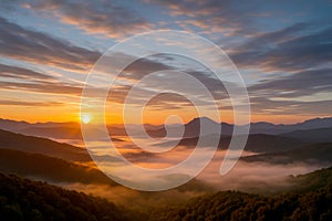 A dramatic sunset over a misty mountain landscape, golden sun rays breaking through dramatic clouds