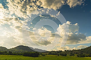 Dramatic sunset over mountain landscape. Beautiful landscape foggy hills twilight time. Blue golden sky sunrise dramatic beautiful