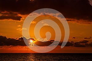 Dramatic sunset over ocean. Sky with clouds