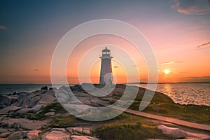 A dramatic sunset at Peggy\'s Cove Lighthouse Atlantic Coast Nova Scotia Canada.