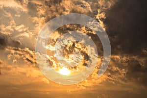 Dramatic sunset sky with orange colored clouds and sun.