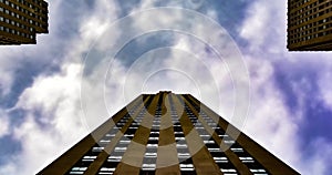 Dramatic timelaps of cloudy sunny day with building on the background. Brick residential building withclouds moving fast