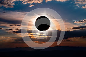Dramatic Total Solar Eclipse at Sunset: Celestial Event Over Silhouetted Mountains