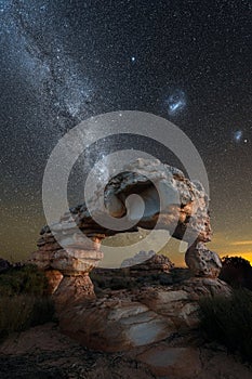 A dramatic vertical night sky landscape photograph of an incredible rock arch