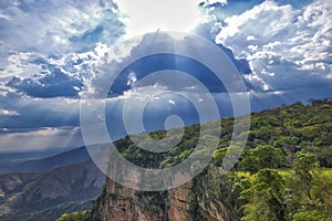 Dramatic view of cliffs with rainforest, sunrays falling through storm clouds, Chapada dos Guimaraes, Mato Grosso, Brazil, South photo