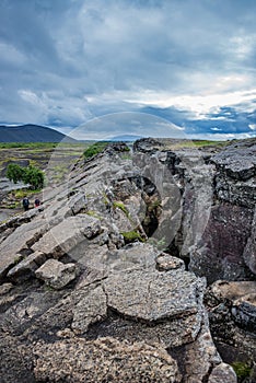 Dramatic view of deep volcanic crustal crack, hiking trail and h