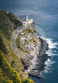 Dramatic view down to lighthouse on Ponta do Arnel, Nordeste, Sao Miguel Island, Azores, Portugal photo