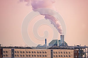 dramatic view factory with steam coming out of chimney, rising into sunset sky, captures power and industry, environmental impact