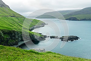 Dramatic view of green hills of Vagar island and Sorvagur town photo