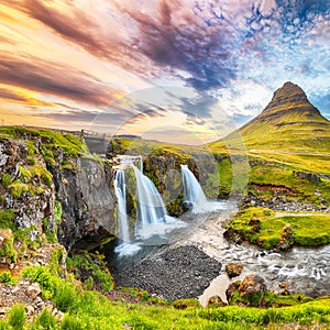 Dramatic view on Kirkjufellsfoss waterfall  near Kirkjufell mountain at sunset