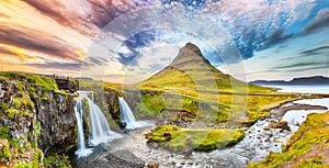 Dramatic view on Kirkjufellsfoss waterfall  near Kirkjufell mountain at sunset