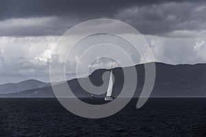 Dramatic view of a sailing boat on the sea before the storm