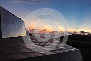 Sharp Lines of Building Against Soft Evening Sky and Sea Horizon