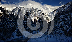 Dramatic Winter Clouds, Crystalline Alpine Snow, and icy stream in Rocky Mountains, Colorado