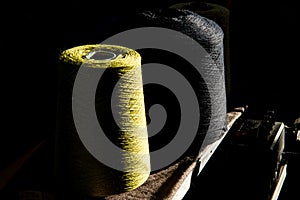 Dramatically Lit Spools of Green and Black Thread
