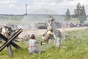 dramatization. soldier of great patriotic war holding a rifle. a lot of smoke. there are civilians