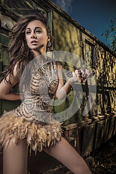 Dramatized image of sensual & attractive young woman in luxury dress posing outdoors.