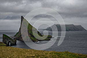 Drangarnir gate, Tindholmur and Mykines under cloudy sky in Faroe Islands
