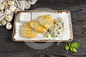 Draniki. Potato pancakes with mushrooms and sour cream. Traditional Belarusian hot second course of grated potatoes, mushrooms, he