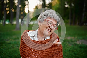 Dranny in blanket leisures on grass in summer park