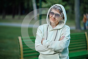 Dranny in hoodie and sunglasses leisures in park