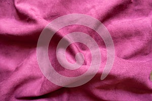 Draped cerise-colored faux suede fabric from above