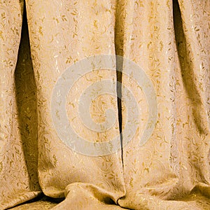 Drapes of golden damask material