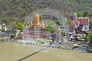 Draw bridge and temples in Laxman Jhula at the Ganga in India