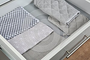 Drawer with folded towels and oven mittens. Order in kitchen