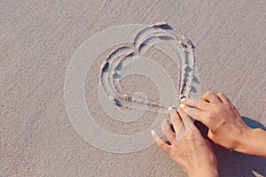 Drawing on beach sand heart symbol