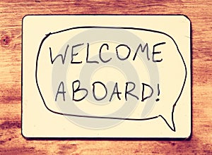 Drawing board with the phrase welcome aboard handwritten over wooden board