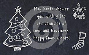 Drawing of christmas tree and handwritten greetings on black chalkboard