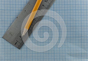 drawing compass, pencil, and ruler on graph paper background