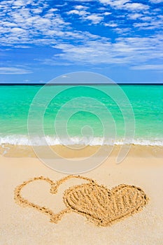 Drawing connected hearts on beach