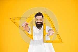 For drawing, draughting and design. Hipster holding drawing instruments on yellow background. Architect and engineer