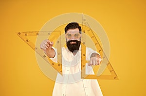 For drawing, draughting and design. Hipster holding drawing instruments on yellow background. Architect and engineer